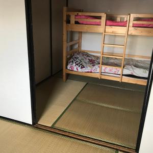 2 beliches num pequeno quarto com um espelho em 山下ビル307 em Kurosakimachi