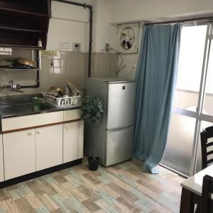 uma cozinha com armários brancos e uma cortina azul em 山下ビル307 em Kurosakimachi