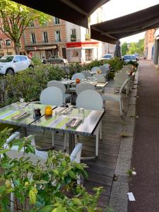 una fila de mesas y sillas en un patio en L'Auberge des 3 Marches, en Le Vésinet