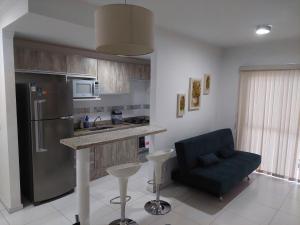 a kitchen with a counter and a blue chair in it at Apartamento Moderno Poços de Caldas in Poços de Caldas