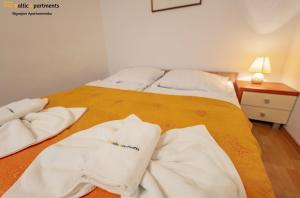 Zwei weiße Handtücher liegen auf einem Bett. in der Unterkunft Baltic Apartments - Zdrojowa in Świnoujście