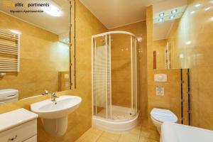 La salle de bains est pourvue d'une douche, d'un lavabo et de toilettes. dans l'établissement Baltic Apartments - Zdrojowa, à Świnoujście