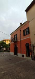 - un bâtiment rouge avec balcon dans une rue dans l'établissement Ideale per escursionisti, a pochi minuti dal mare e dalle falesie- Casa Celeste, à Cisano sul Neva