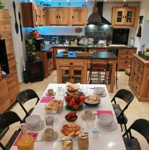 una cocina con una mesa con comida. en "Les Chaillottes", en Chailles