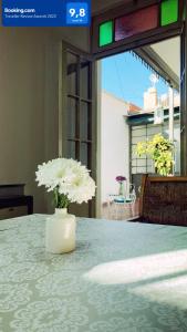 um vaso com flores brancas sentado numa mesa em Alem Colonial em Mendoza