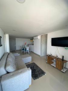 ein Wohnzimmer mit einem Sofa und einem Flachbild-TV in der Unterkunft Vista mar!! in Cartagena de Indias