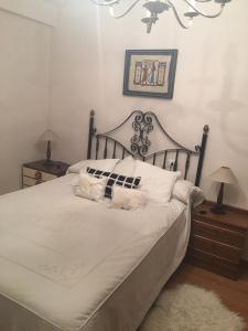 1 dormitorio con 1 cama blanca grande y 2 almohadas en Apartamento Gijon Playa, en Gijón