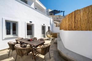 a patio with a wooden table and chairs at Astivi Santorini Apartments in Pyrgos
