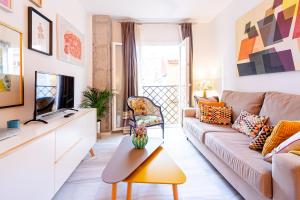 a living room with a couch and a tv at Apartamento Vicky Victoria in Málaga