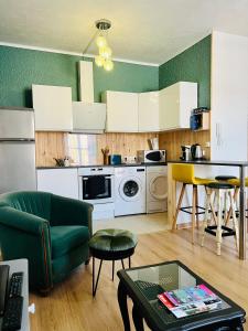 uma cozinha com um sofá e uma mesa num quarto em Ravissant T2 proche centre-ville et Jard em Châlons-en-Champagne