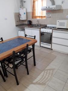 uma cozinha com uma mesa de madeira e um fogão em Departamento Anita centro em Maipú