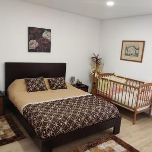 a bedroom with a large bed and a crib at Dina House in Boticas