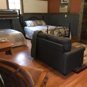 ein Wohnzimmer mit einem Sofa und einem Bett in der Unterkunft Acorn Hideaways Canton Old West Bunkhouse for 9 - Trail's End Corral in Canton