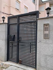 een zwarte poort met witte stippen op een gebouw bij VuT Las Almenas in Avila