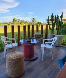 a patio with a table and chairs and cactus at Villa das Águas - Térreo frente lago in Estância +32 photos