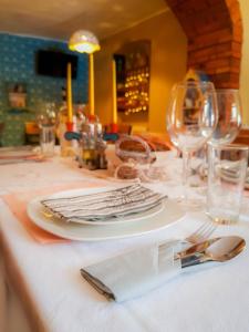 a table with a white plate and glasses on it at Papa la Șoni Gastro-Pensiune in Borsec