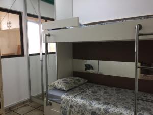 - une chambre avec des lits superposés et un couvre-lit dans l'établissement APARTAMENTO 3 DORM., O QUINTAL É A PRAIA E MOLHES, à Laguna