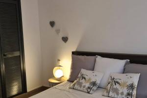 una camera da letto con un letto con palme sul muro di Antilo - appartement proche mer a Le Diamant