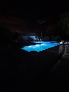 una foto notturna di una piscina di Antilo - appartement proche mer a Le Diamant
