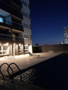 una piscina con sillas y un edificio por la noche en Malala departamento en Santa Fe - ALOJAMIENTO DE CALIDAD en Santa Fe