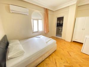 a bedroom with a large white bed and a window at Mimoza Pansiyon in Antalya
