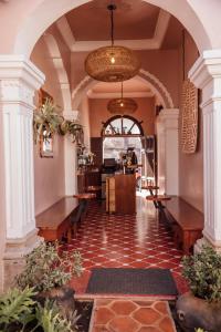 a hallway with an archway with benches and a table at Ojala in Antigua Guatemala