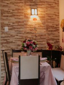 Casa Inteira aconchegante com garagem Próximo ao Aeroporto في لورو دي فريتاس: غرفة طعام مع طاولة مع إناء من الزهور