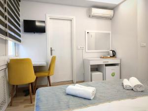 イスタンブールにあるOlen Altunizade Hotelのベッドルーム1室(黄色い椅子、デスク付)
