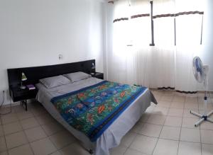 a bedroom with a bed with a colorful blanket on it at Conjunto vacacional Cocomar-Casa 6 - 3h in Carrizal