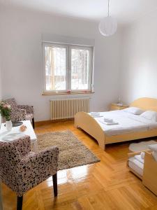a bedroom with a bed and a table and a chair at Bueno Apartment in Belgrade