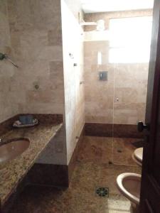 ein Bad mit einer Dusche, einem Waschbecken und einem WC in der Unterkunft Cabo Frio Líder da Praia in Cabo Frio