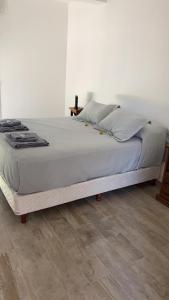 uma cama grande num quarto com piso em madeira em Duplex Jardines del Rey em Neuquén