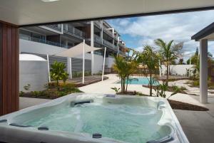 a jacuzzi tub sitting outside of a building at Tahunanui Oceanview Apartment in Nelson