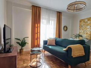 sala de estar con sofá azul y mesa en Misterhost Santa Cruz II -Jardines de Murillo, en Sevilla