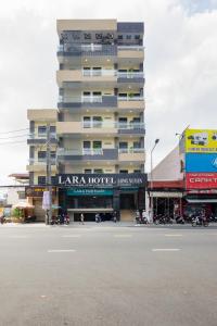 a tall building with a hotel on the side of a street at LARA HOTEL LONG XUYÊN in Long Xuyên