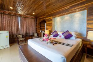 a bedroom with a large bed with two dolls on it at Gooddays Lanta Beach Resort SHA in Ko Lanta
