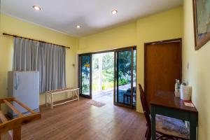 a kitchen with yellow walls and a table and a refrigerator at Gooddays Lanta Beach Resort SHA in Ko Lanta
