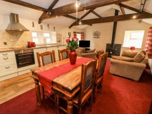 a kitchen and living room with a wooden table and chairs at Anvil Barn in Bainbridge