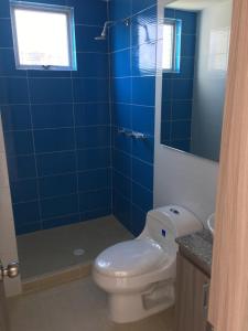 a blue tiled bathroom with a toilet and a shower at Lindo Apto Rodadero Sur, Santa Marta in Gaira