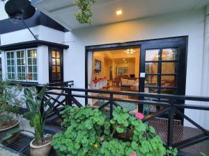 een huis met een balkon met planten ervoor bij Gerard's Place Nature Haven Apartment in Tanah Rata
