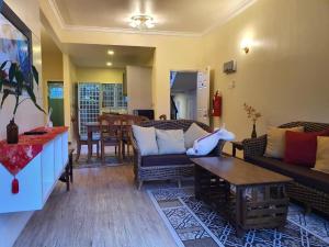 een woonkamer met een bank en een tafel bij Gerard's Place Nature Haven Apartment in Tanah Rata