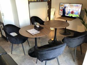 un ristorante con due tavoli e sedie e una TV di Cool-inn Otaru a Otaru