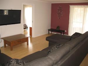 a living room with a couch and a flat screen tv at Paradise on The Boulevard - Beach Holiday Home 