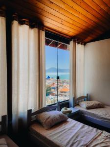 Hostel Vista da Barra في فلوريانوبوليس: غرفة نوم بسريرين ونافذة كبيرة