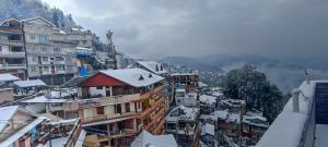 una ciudad cubierta de nieve con edificios en Hotel Amaira en Darjeeling