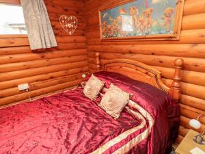 um quarto com uma cama num chalé de madeira em Farnes em Morpeth