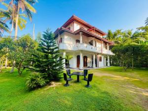 una casa con un tavolo da picnic di fronte di Villa Sureka a Hikkaduwa