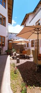 eine Terrasse mit einem Tisch, Stühlen und Sonnenschirmen in der Unterkunft 7th Wonder Apart Hotel Cusco in Cusco