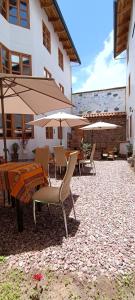 a patio with a table and chairs and umbrellas at 7th Wonder Apart Hotel Cusco in Cusco