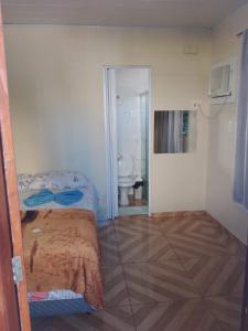 a bedroom with a bed and a bathroom with a toilet at Hostel Morais in Maceió